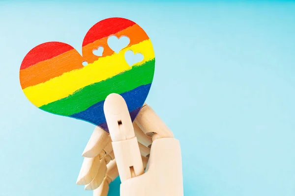 stock image Rainbow heart in artificial arm on blue background. LGBT equal rights movement and gender equality concept. Copy space