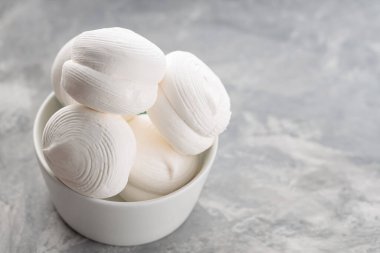 Zephyr lokumları gri arka planda kasede. Betonda tatlı marşmelovları. Boşluğu kopyala