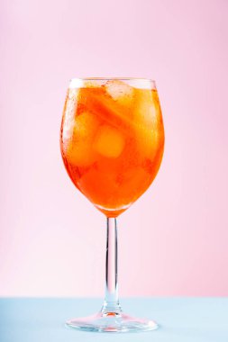 Aperol Spritz kokteyli, pembe mavi arka planda. Turuncu ve buzlu Aperol Spritz kokteyli. Kapat.