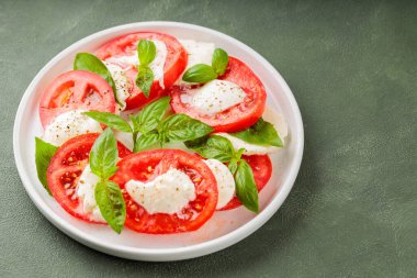 Taze İtalyan caprese salatası mozzarella ve beyaz tabakta domatesler. Üst Manzara. Boşluğu kopyala