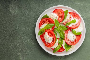 Taze İtalyan caprese salatası mozzarella ve beyaz tabakta domatesler. Üst Manzara. Boşluğu kopyala