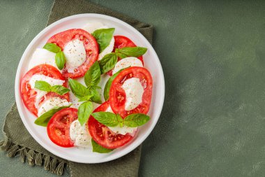 Taze İtalyan caprese salatası mozzarella ve beyaz tabakta domatesler. Üst Manzara. Boşluğu kopyala