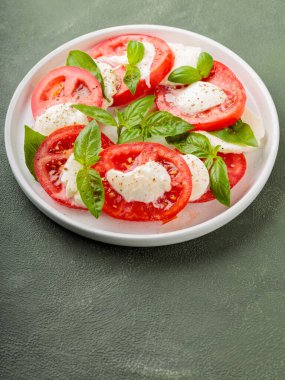 Taze İtalyan caprese salatası mozzarella ve beyaz tabakta domatesler. Üst Manzara. Boşluğu kopyala