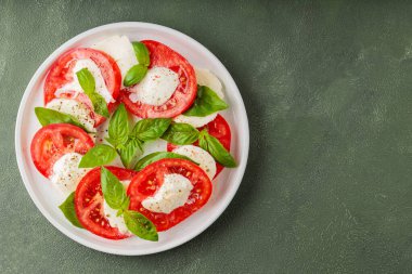 Taze İtalyan caprese salatası mozzarella ve beyaz tabakta domatesler. Üst Manzara. Boşluğu kopyala