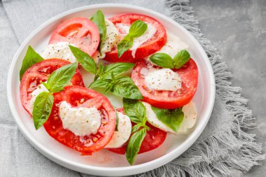 Beyaz Tabakta Caprese Salatası ve Şık Gri Keten Peçete. Kapat.