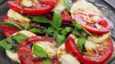 Siyah tabakta Caprese salatası. Mozzarella ve fesleğen yapraklı domates salatası. Organik yiyecekler