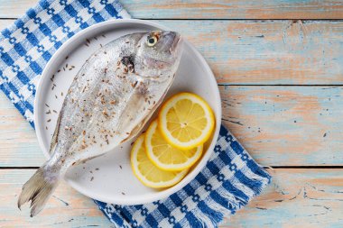 Eski tahtalarda baharatlı ve limonlu taze çiğ dorado balığı. Boşluğu kopyala