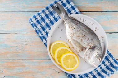 Eski tahtalarda baharatlı ve limonlu taze çiğ dorado balığı. Boşluğu kopyala