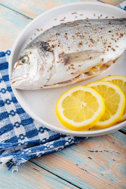 Eski tahtalarda baharatlı ve limonlu taze çiğ dorado balığı. Boşluğu kopyala