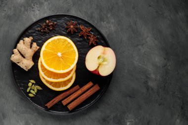 Siyah tabakta sıcak şarap için baharat ve meyve. Üst Manzara. Boşluğu kopyala