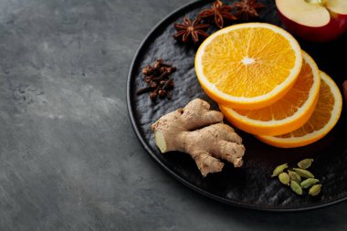 Siyah tabakta sıcak şarap için baharat ve meyve. Üst Manzara. Boşluğu kopyala