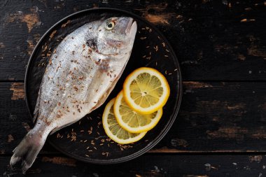 Koyu arkaplanda limonlu taze dorado balığı. Akdeniz mutfağı. Boşluğu kopyala