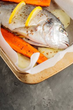 Sebzeli taze çiğ dorado balığı ve limon dilimleri. Üst Manzara. Boşluğu kopyala