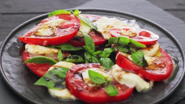 Ensalada Caprese Con Hojas Mozzarella Tomate Albahaca Sobre Plato Negro — Vídeos de Stock