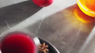 Gri arka planda sıcak şarap kadehi ve malzemeleri yakın plan. El kamerasıyla.