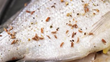 Çiğ doldurulmuş dorado balığı kimyon tohumları serpiştirilmiş. Makro çekim