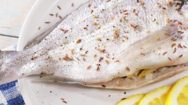 Limonla doldurulmuş taze Dorado levreği, fırında pişirmeye hazır. Dönen kamera görüntüsü