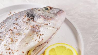Limonla doldurulmuş taze Dorado levreği, fırında pişirmeye hazır. Dönen kamera görüntüsü