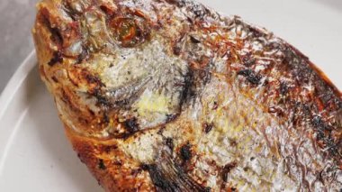 Altın hamurlu fırında Dorado Balığı ve beyaz tabakta limon dilimleri. Kapat.