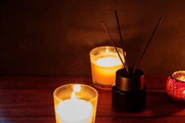 Serene Aromaterapi Ayarları: Tahta Masada Reed Yayıcı ve Yanan Mumlar