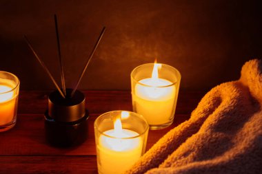 Reed Diffuser, Battaniye ve Mumlarla Tahta Masa Üzerinde Rahatlatıcı Aromaterapi