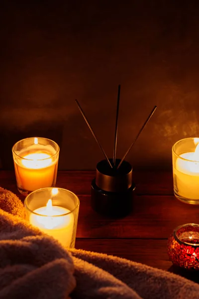 Soothing Aromatherapy with Reed Diffuser, Blanket and Candles on Wooden Table