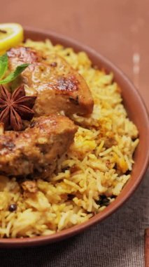 Tavuk Biryani in Clay Bowl on Brown Background, Panning Camera shot, Dikey Video