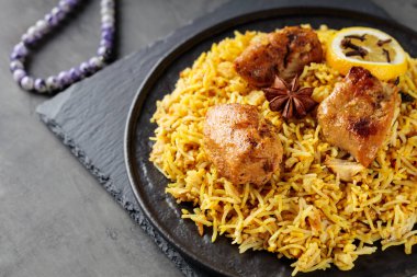 Ramazan iftarı için Biryani usulü tavuk, siyah tabakta basmati pilavı, Ramazan yemeği, yakın çekim.