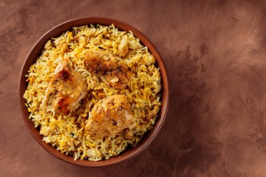 Tavuk Biryani in Clay Bowl on Brown Background, Copy Space, Top View