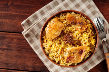 Tahta Masa üzerinde kızarmış tavuk ve yıldız anasonlu tavuk biryani, keten peçete ve çatal bıçakla servis edilir, kopyalama alanı, üst görünüm