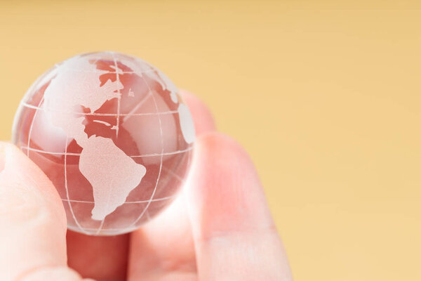 Концепция Дня Земли, стеклянный глобус состоялся в ладони человека, защита экосистем, копирования пространства