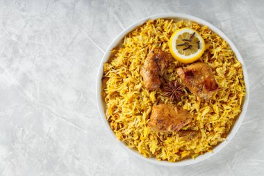 Hint Tavuk Biryani ile Basmati Rice, Star Anise, karanfil ve limon beyaz tabakta, kopyalama alanı, üst görünüm