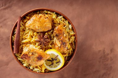 Tavuk Biryani ile kızarmış tavuk, baharat ve limon kahverengi arka planda, Top View, Copy Space