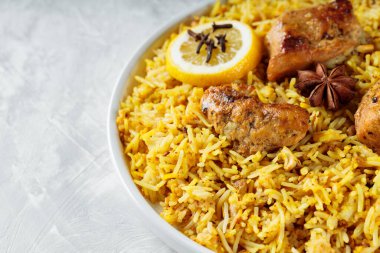 Gri arka planda geleneksel tavuk biryani tabağı, Hint mutfağı konsepti
