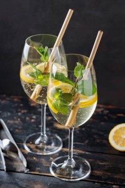 Hugo Spritz Kokteyli 'ni Yaşlı Çiçek Likörü, Nane ve Limon ile Karanlık Arkaplanda Yenilemek