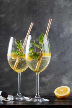 Hugo Spritz Kokteyli 'ni Yaşlı Çiçek Likörü, Nane ve Limon ile Karanlık Arkaplanda Yenilemek