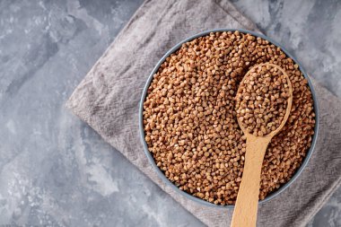 Bowl 'da Karabuğday Taneleri ve Gri Arkaplan' da Tahta Kaşık, Üst Görünüm, Boşluğu Kopyala