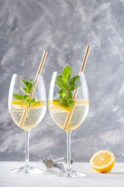 Hugo Spritz Kokteyli Nane Şekeri ve Limonla süslenmiş Beton Üzerine Bambu Çubuğu