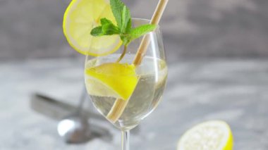 Hugo Spritz Naneli, Limonlu ve Bambu Çubuklu Kokteyl Gri Beton Arkaplanda, El Fotoğrafı