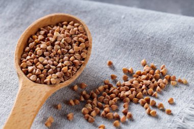 Tahta kaşıkta pişirilmemiş karabuğday, Gri Arka plan, Yakın plan