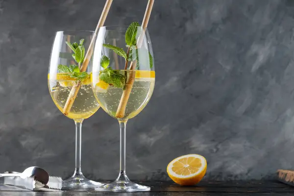 stock image Hugo Spritz Cocktails in Glasses with Mint, Lemon and Cocktail Straws on Dark Background, Copy Space