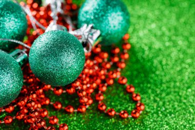 Işıltılı Yeşil Noel Baloları Parlayan Yeşil Arkaplanda Kırmızı Boncuklar, Noel ve Yeni Yıl Dekorasyonları, Kopyalama Alanı