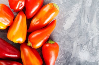 Sağlıklı Vejetaryen Aşçılığı İçin Gri Yüzeyde Taze Hasat Kırmızı ve Portakal Çanı Biberleri, Kopyalama Alanı