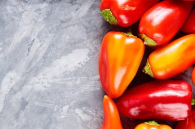 Sağlıklı Vejetaryen Aşçılığı İçin Gri Yüzeyde Taze Hasat Kırmızı ve Portakal Çanı Biberleri, Kopyalama Alanı
