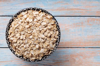 Bir kase pişmemiş yulaf gevreği Rustik ahşap yüzeye yerleştirildi, Üst Görünüm, Kopyala Uzay