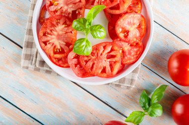 Taze Domates Dilimleri ve Basil Yaprakları Beyaz Tabakta, Kırsal Ahşap Arkaplan, Üst Görünüm, Uzayı Kopyala