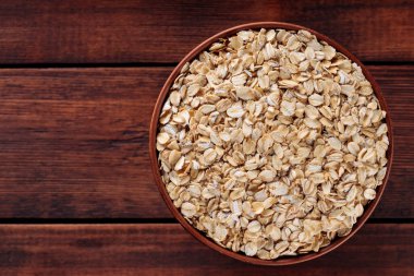 Kahverengi çömlek içinde pişmemiş yulaf ezmesi vegan diyeti ve tam tahıllı beslenme, kopyalama alanı, üst görünüm