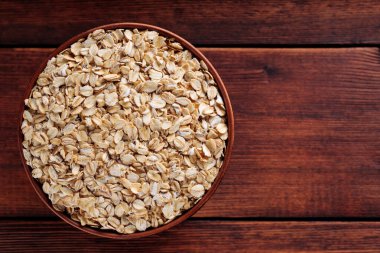 Kahverengi çömlek içinde pişmemiş yulaf ezmesi vegan diyeti ve tam tahıllı beslenme, kopyalama alanı, üst görünüm