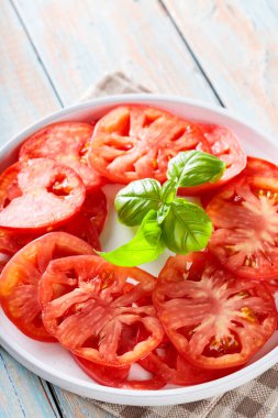 Beyaz Tabak Domates Dilimleri ve Basil Yaprakları Kırsal Tahta Masada, Yakın Çekim