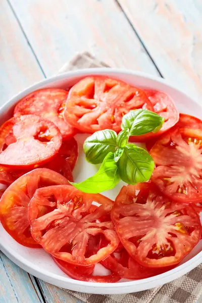Beyaz Tabak Domates Dilimleri ve Basil Yaprakları Kırsal Tahta Masada, Yakın Çekim